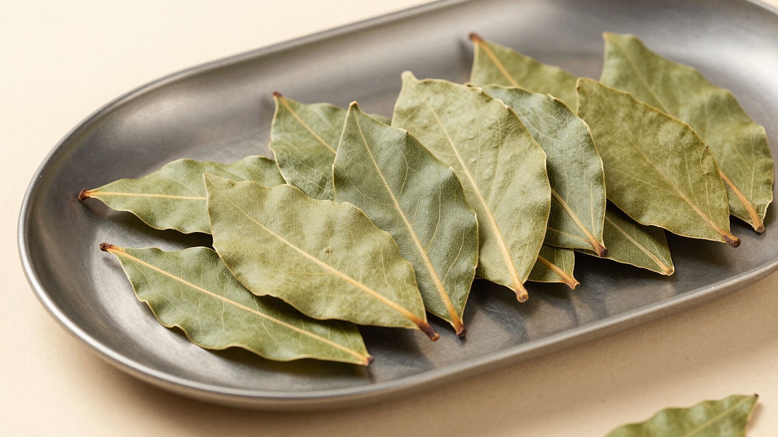 Whole dried Georgian bay leaves arranged on a metal tray